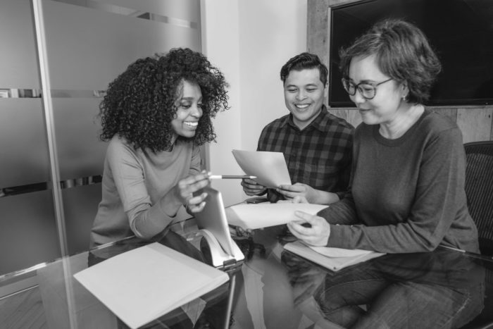 Two job seekers meeting with a recruiter, having responded favorably to their inclusive job descriptions.