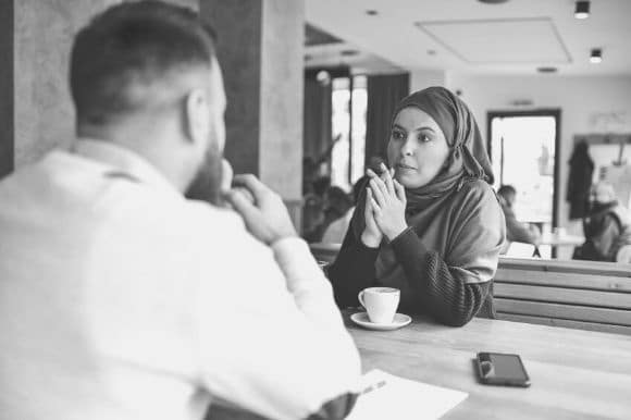A manager interviews a job candidate over coffee.